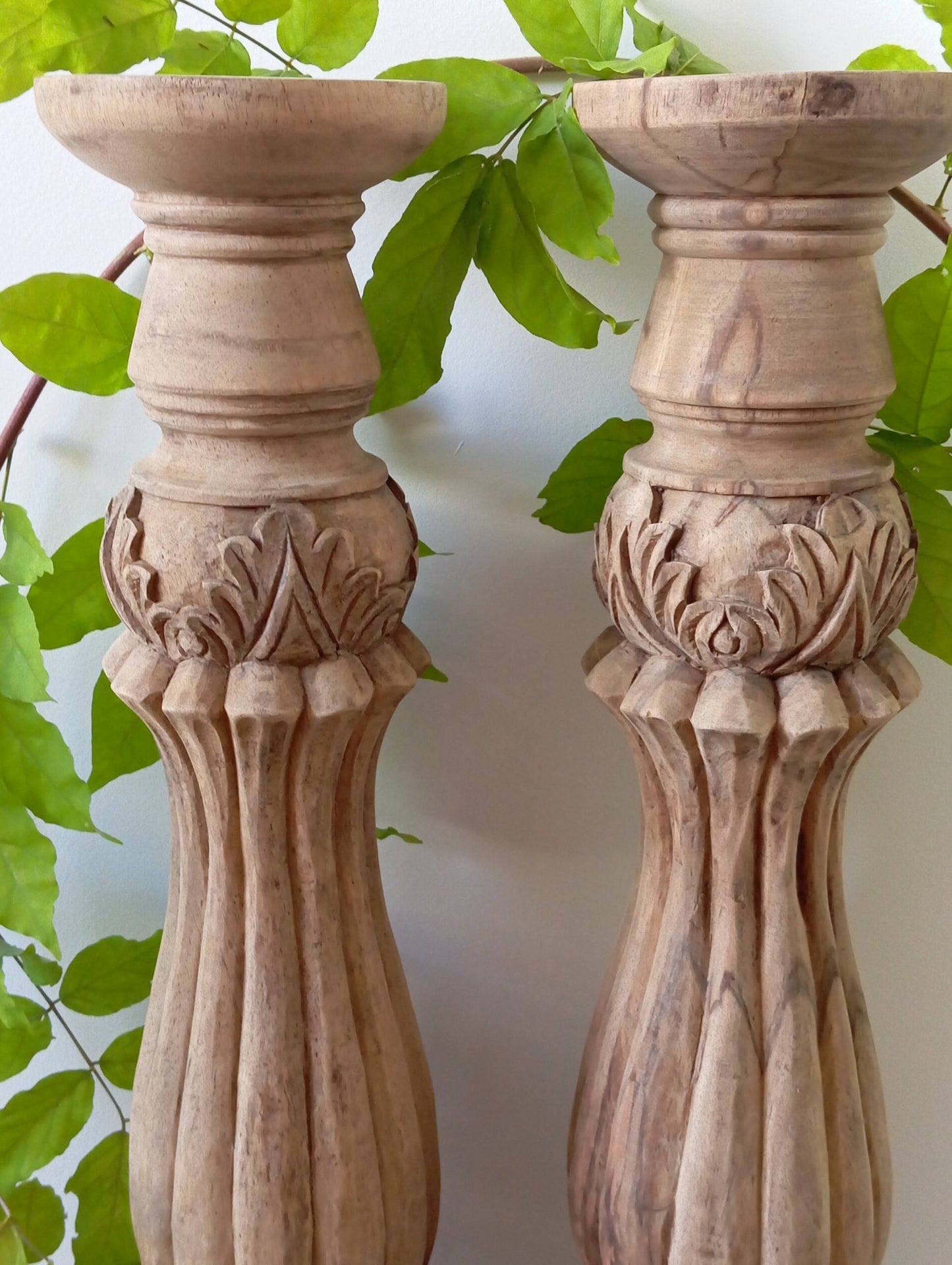 Two solid wood candlesticks on a stand