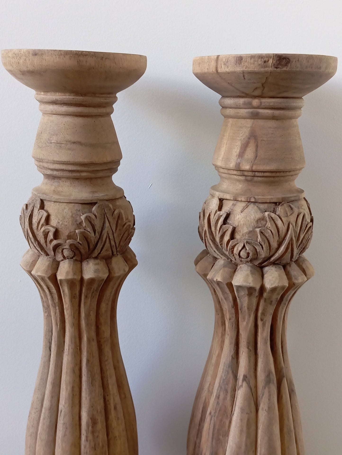 Two solid wood candlesticks on a stand